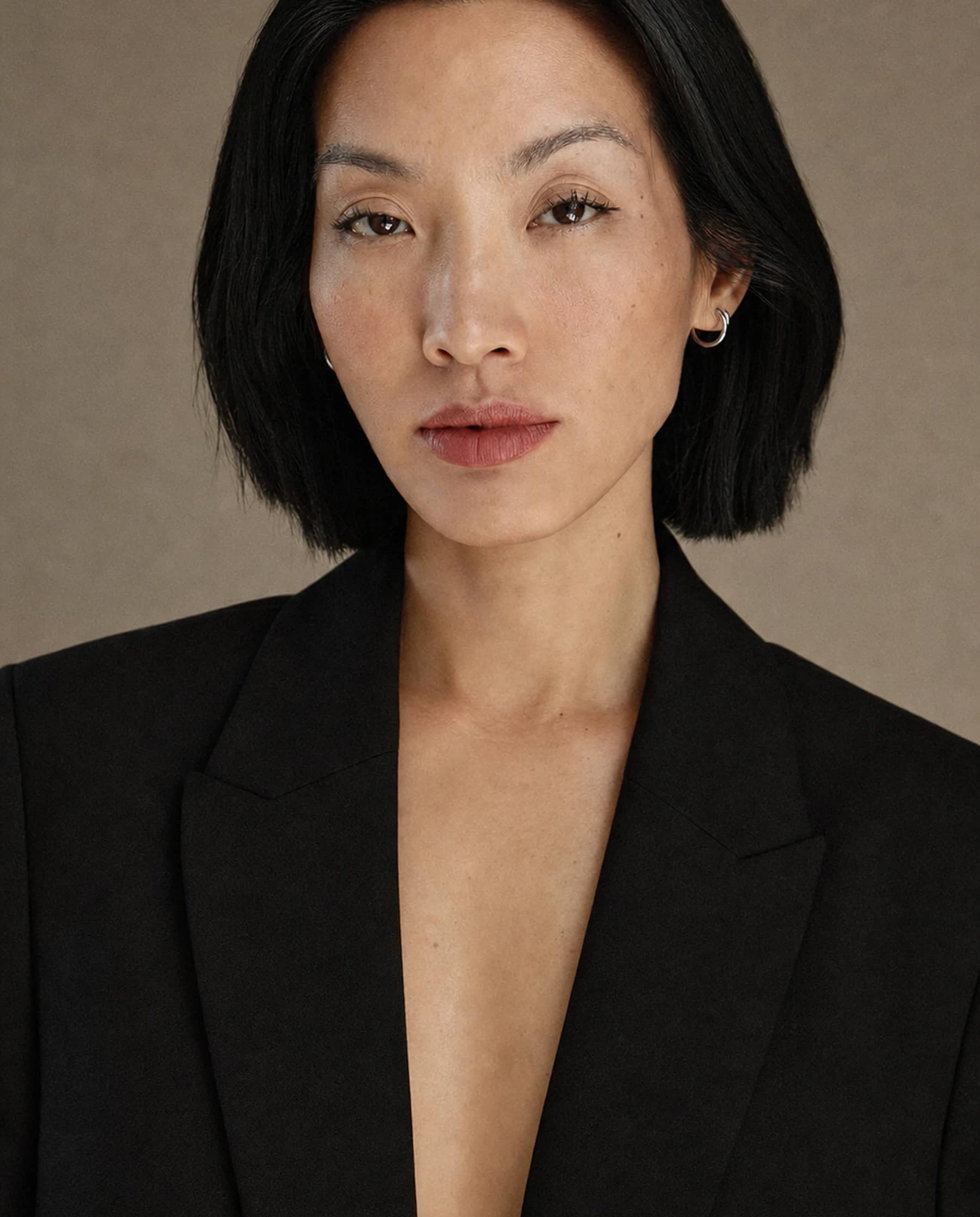 AI-generated studio portrait of cofounder Piyawan “Gift” Chitsamran in a black blazer, chin-length black bob