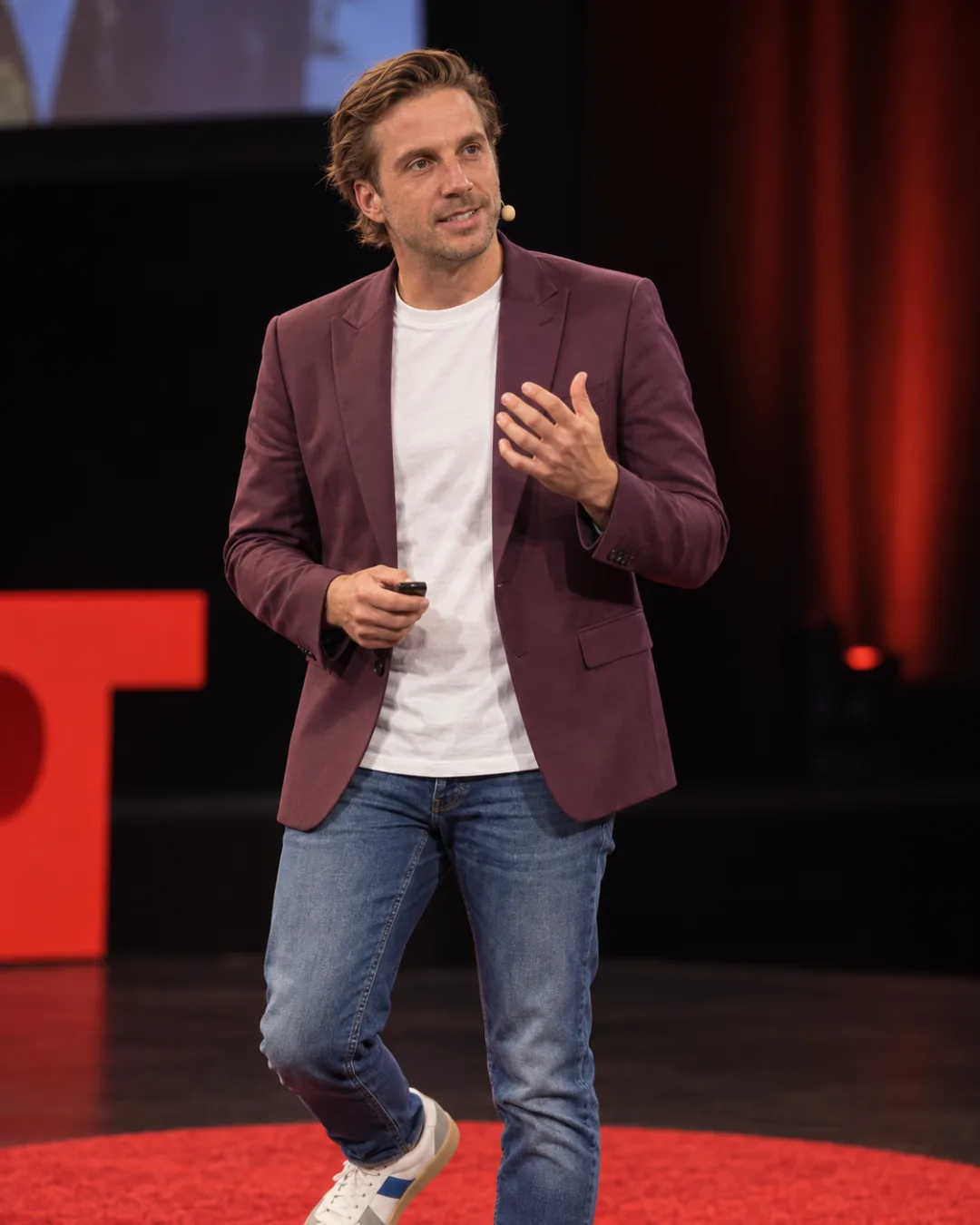 The founder walking a conference stage, mid-stride