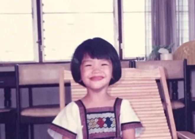 Childhood photo of Piyawan “Gift” Chitsamran smiling, bob haircut, Thailand