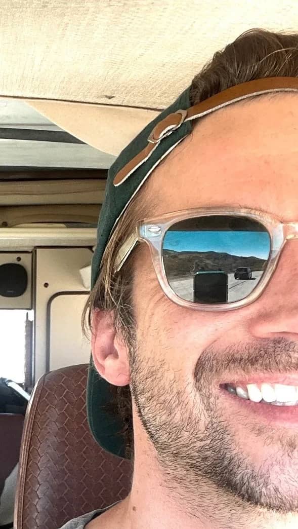 Mathieu Wauters in sunglasses and a cap inside a camper van