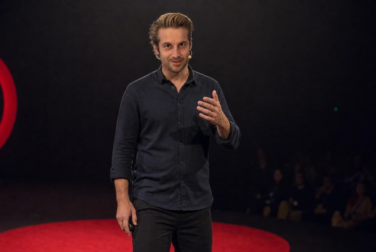 AI-generated photo of Mathieu speaking on a TED-style conference stage