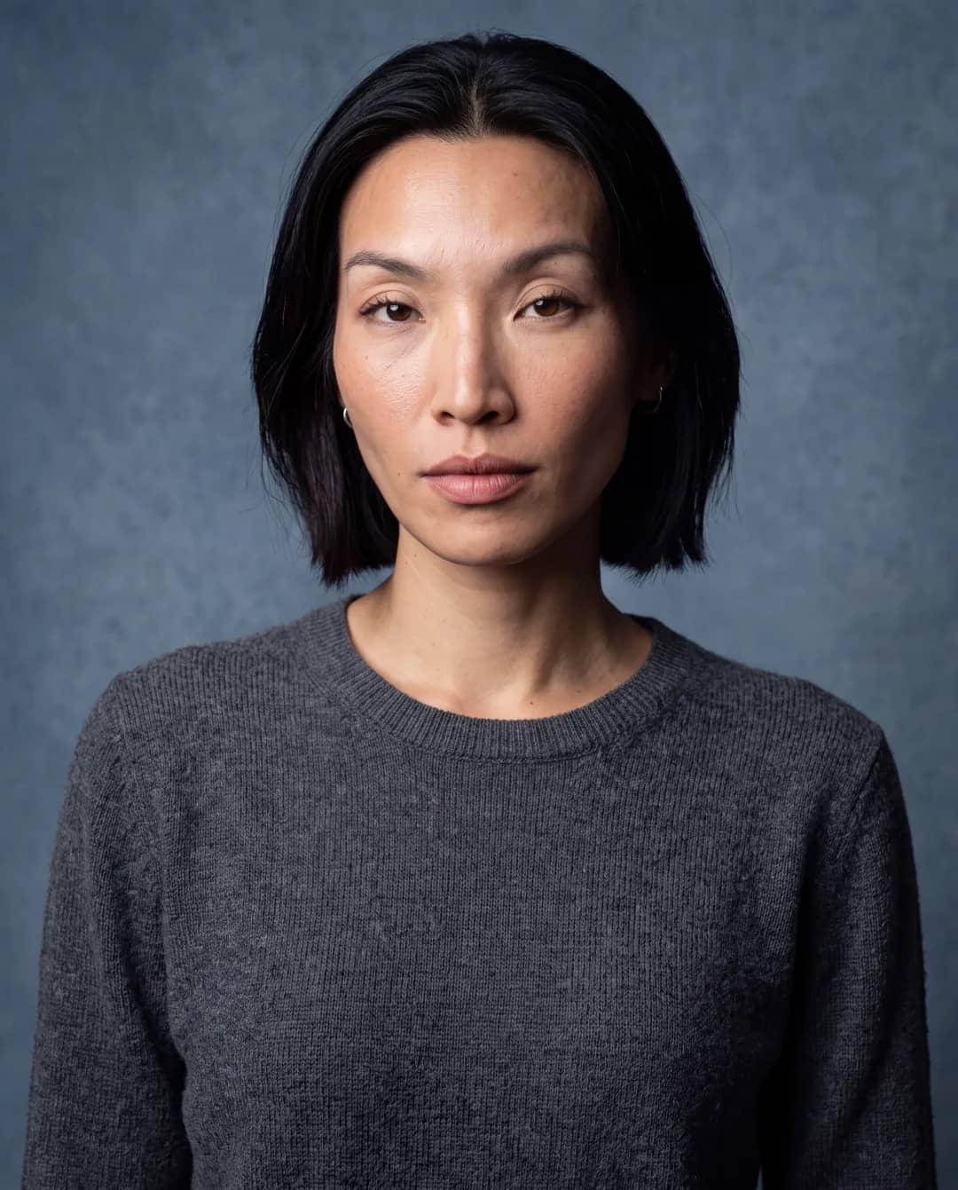 AI-generated First Look frame of Promptography cofounder Gift: a frontal studio headshot in a charcoal crew-neck sweater