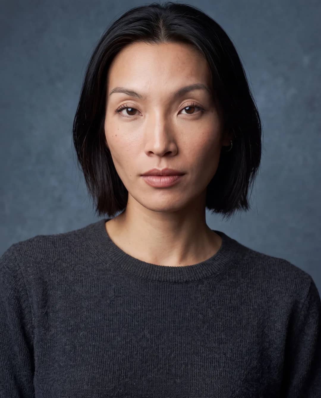 AI-generated First Look frame of Promptography cofounder Gift: a closer frontal studio headshot showing her chin-length black bob